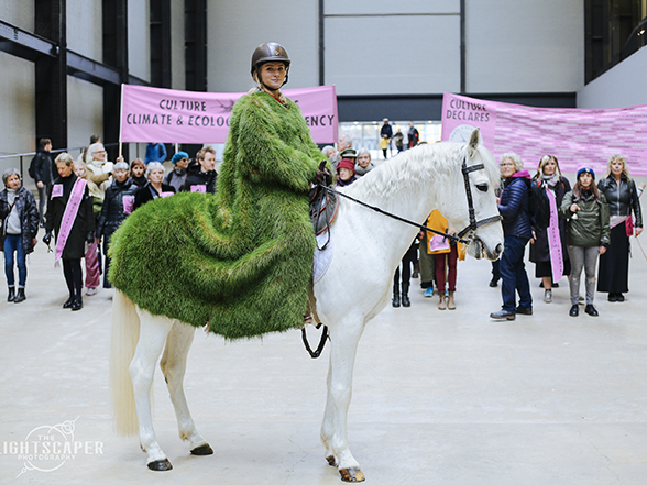 Culture Declares Emergency with banners, a white horse and a rider in a grass coat.